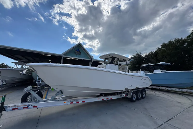 Slide: The Image of 2026 Solace 32 CS boat on trailer under cloudy sky at marina. - 3