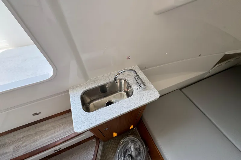 Slide: The Image of 2026 Solace 32 CS boat interior with compact sink and seating area. - 30