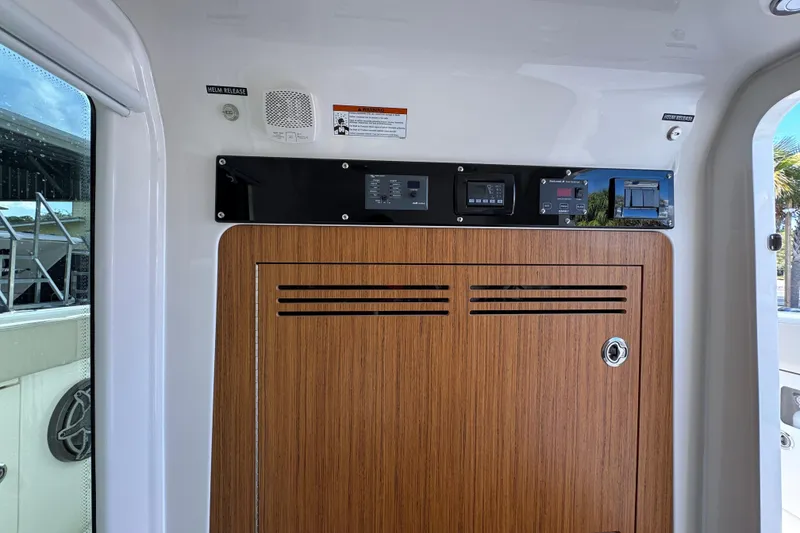 Slide: The Image of Interior view of 2026 Solace 32 CS boat with control panel and wooden cabinet. - 32