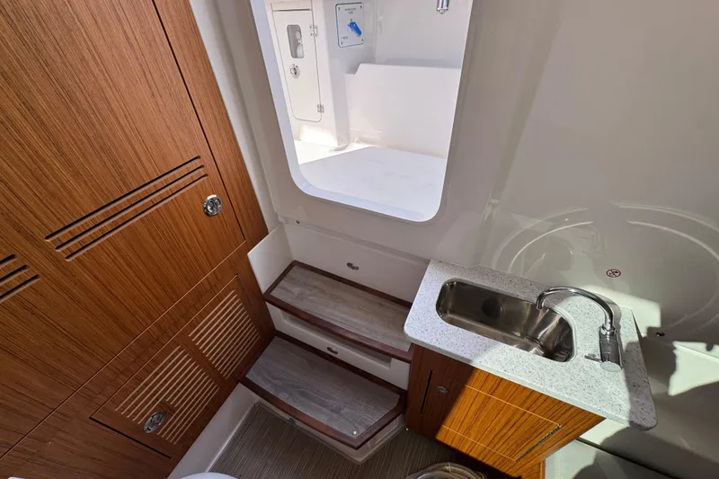 Slide: The Image of Interior of 2026 Solace 32 CS boat with wooden cabinetry and compact sink. - 33