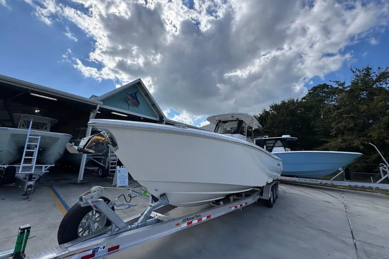 Slide: The Image of 2026 Solace 32 CS boat on trailer under cloudy sky at dealership. - 4