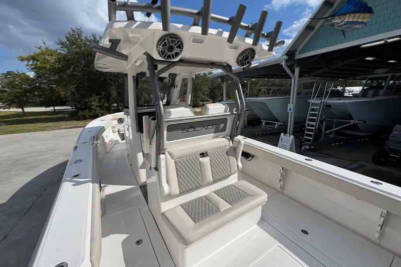Slide: The Image of 2026 Solace 32 CS boat with modern seating and sleek design in a marina setting. - 43