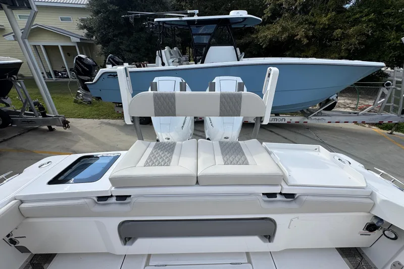 Slide: The Image of 2026 Solace 32 CS boat with cushioned seating and dual outboard motors. - 49