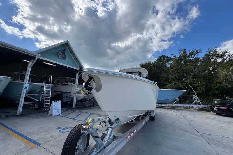 Slide: The Image of 2026 Solace 32 CS boat on trailer outside dealership under cloudy sky. - 5