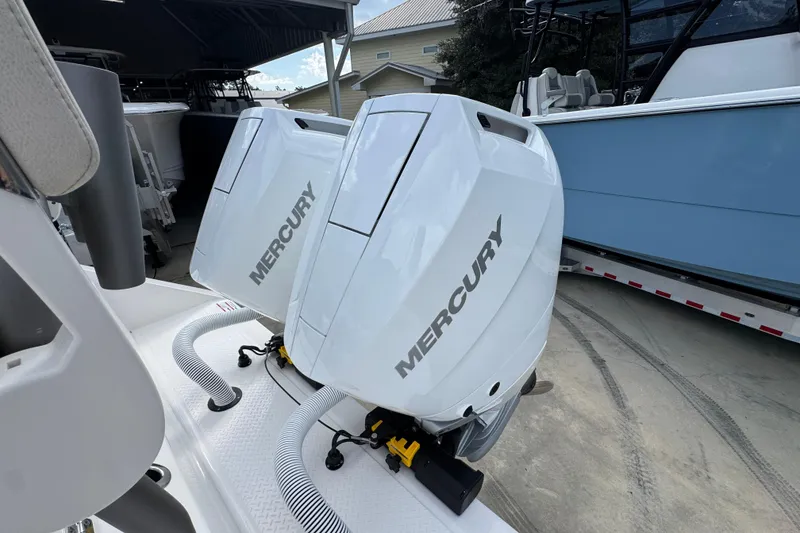 Slide: The Image of Twin Mercury outboard engines on a 2026 Solace 32 CS boat, parked outdoors. - 54