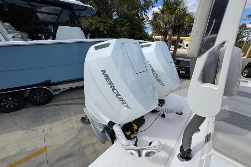 Slide: The Image of 2026 Solace 32 CS boat with dual Mercury outboard engines, parked on a trailer. - 55