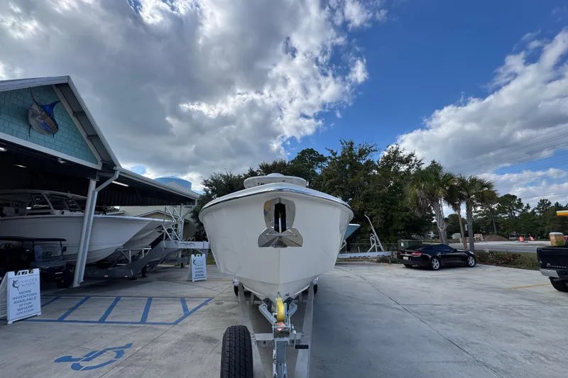 Slide: The Image of 2026 Solace 32 CS boat on trailer at dealership under cloudy sky. - 6