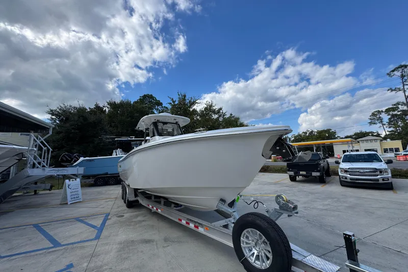 Slide: The Image of 2026 Solace 32 CS boat on trailer in parking lot under cloudy sky. - 7
