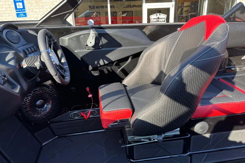 Slide: The Image of Interior of 2026 Supreme S240 boat with black and red seating, steering wheel, and controls. - 10