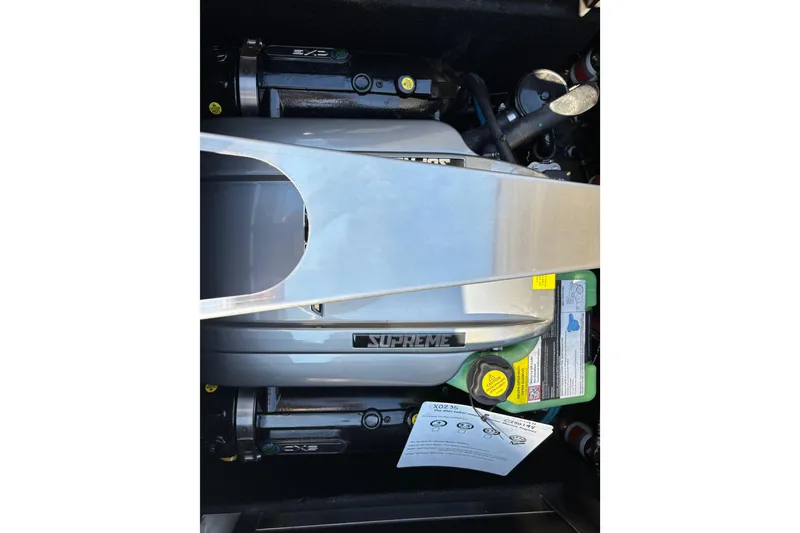 Slide: The Image of Engine compartment of 2026 Supreme S240 boat, showcasing mechanical components and labels. - 13