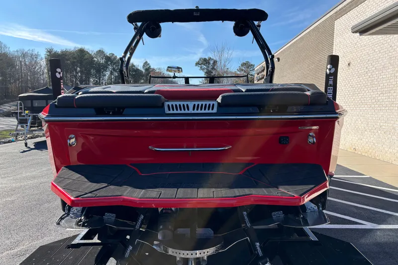 Slide: The Image of Red 2026 Supreme S240 boat rear view, parked outdoors on a sunny day. - 3