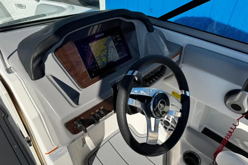Slide: The Image of 2024 Chaparral 21 SSi OB boat dashboard with steering wheel and navigation display. - 39