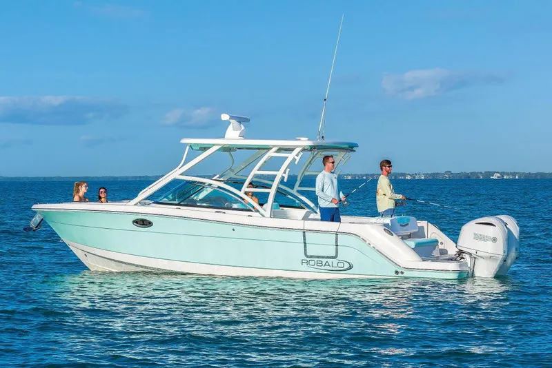 Slide: The Image of Manufacturer Provided Image: 2025 Robalo R317 Dual Console boat on open water with people enjoying the ride. - 1