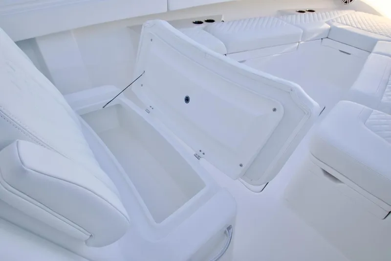 Slide: The Image of 2026 Regulator 31 boat interior with open storage compartment and cushioned seating. - 13