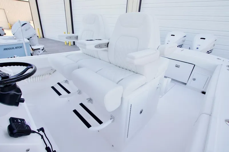 Slide: The Image of 2026 Regulator 31 boat interior with dual white captain's chairs and steering wheel. - 17