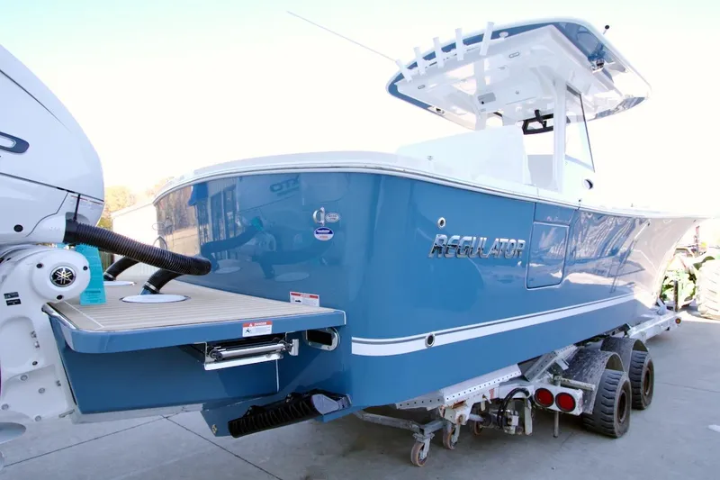 Slide: The Image of 2026 Regulator 31 boat in blue on trailer, rear view. - 2