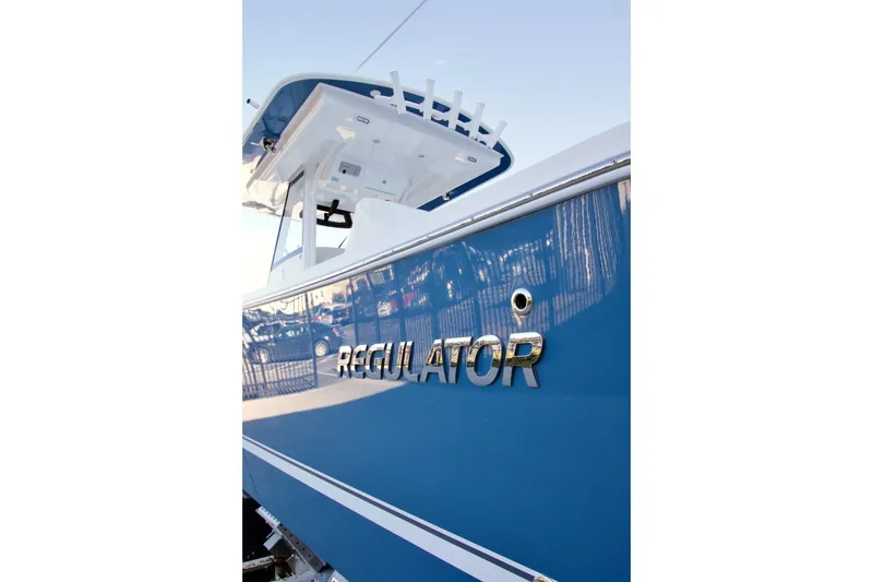 Slide: The Image of 2026 Regulator 31 boat, blue hull, docked, side view with logo. - 5