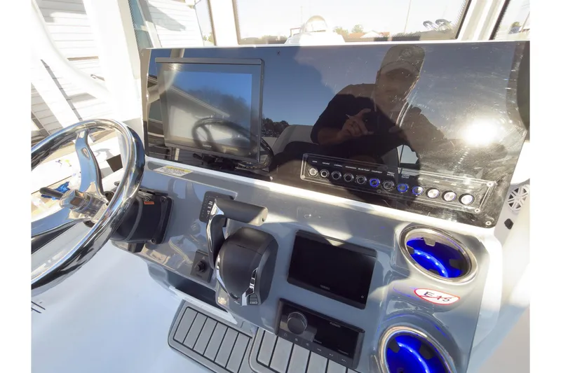 Slide: The Image of 2026 Tidewater 2300 Carolina Bay boat dashboard with steering wheel and control panel. - 12