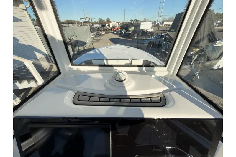 Slide: The Image of 2026 Tidewater 2300 Carolina Bay boat dashboard view with compass and controls. - 13