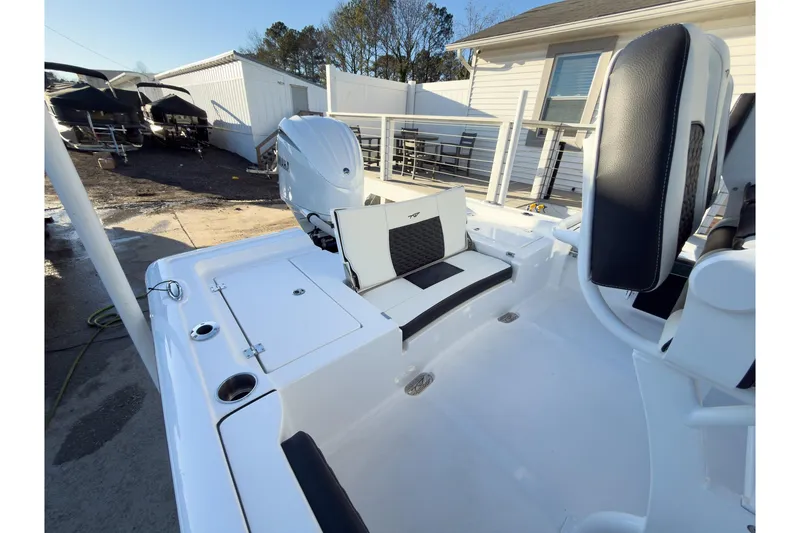 Slide: The Image of 2026 Tidewater 2300 Carolina Bay boat interior with seating and motor, docked outdoors. - 19