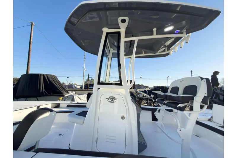 Slide: The Image of 2026 Tidewater 2300 Carolina Bay boat with T-top and seating, under clear blue sky. - 24