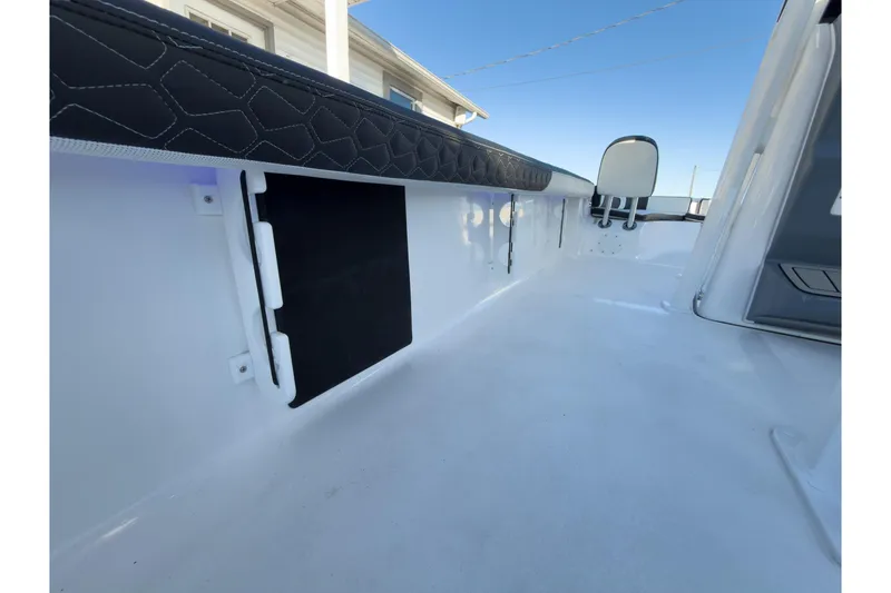 Slide: The Image of 2026 Tidewater 2300 Carolina Bay boat interior with cushioned seating and storage compartment. - 26