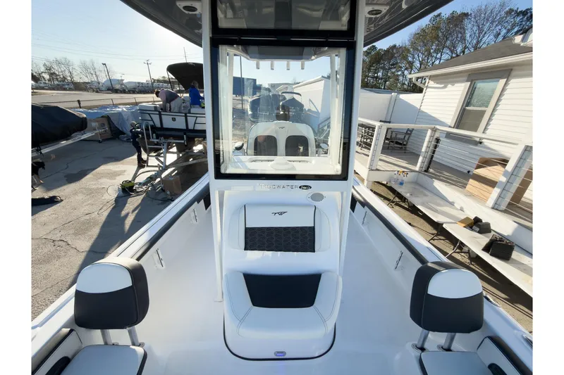 Slide: The Image of 2026 Tidewater 2300 Carolina Bay boat interior with seating and console, docked outdoors. - 41