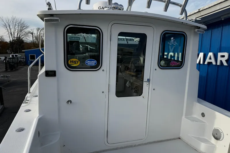 Slide: The Image of 2018 Parker 2520 XLD Sport Cabin boat with white exterior and cabin door. - 10