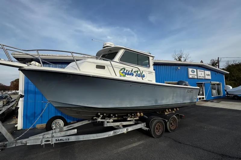 Slide: The Image of 2018 Parker 2520 XLD Sport Cabin boat on trailer outside blue building. - 2