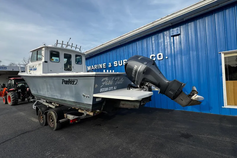 Slide: The Image of 2018 Parker 2520 XLD Sport Cabin boat on trailer outside marine supply store. - 3