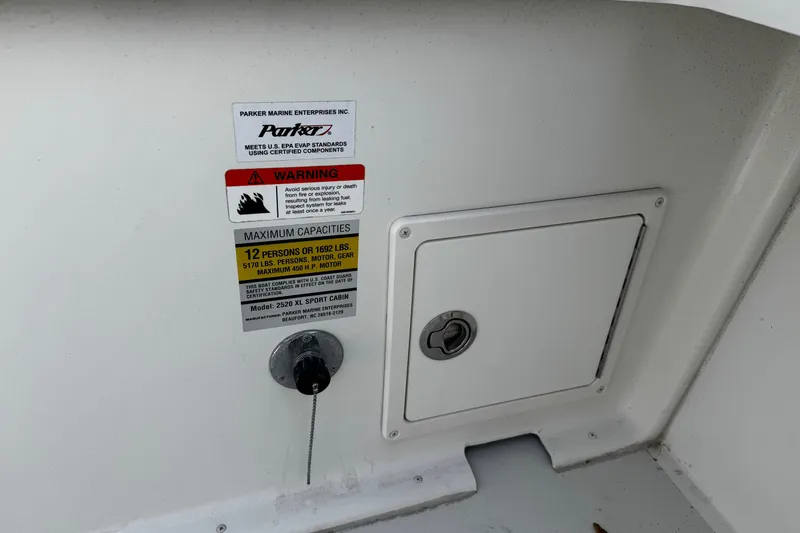 Slide: The Image of 2018 Parker 2520 XLD Sport Cabin capacity and warning labels on boat interior. - 43