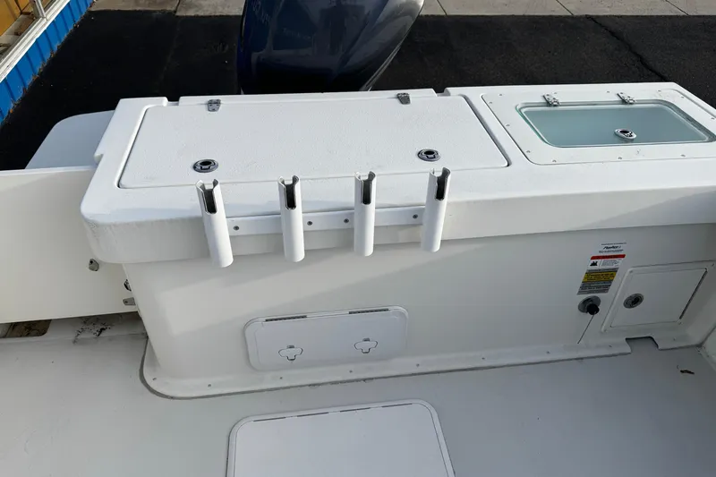 Slide: The Image of 2018 Parker 2520 XLD Sport Cabin boat deck with rod holders and storage compartments. - 6