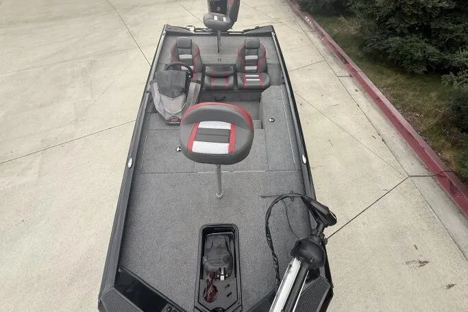 Slide: The Image of 2021 Ranger RT178 fishing boat with gray and red seating, parked on concrete. - 11