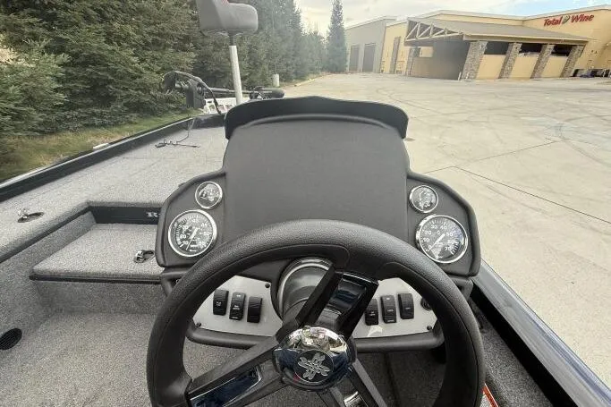 Slide: The Image of 2021 Ranger RT178 boat dashboard with steering wheel and gauges, parked near a building. - 14