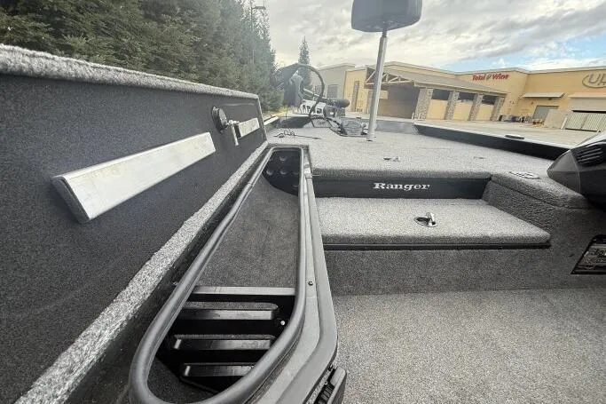 Slide: The Image of 2021 Ranger RT178 boat interior with storage compartments and seating, outdoors near buildings. - 16