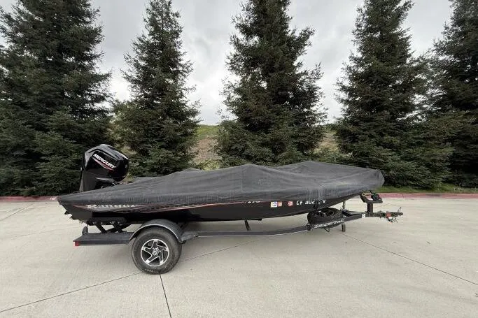 Slide: The Image of 2021 Ranger RT178 boat with cover on trailer, parked outdoors. - 2