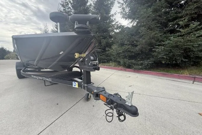 Slide: The Image of 2021 Ranger RT178 boat trailer parked on concrete near trees. - 26