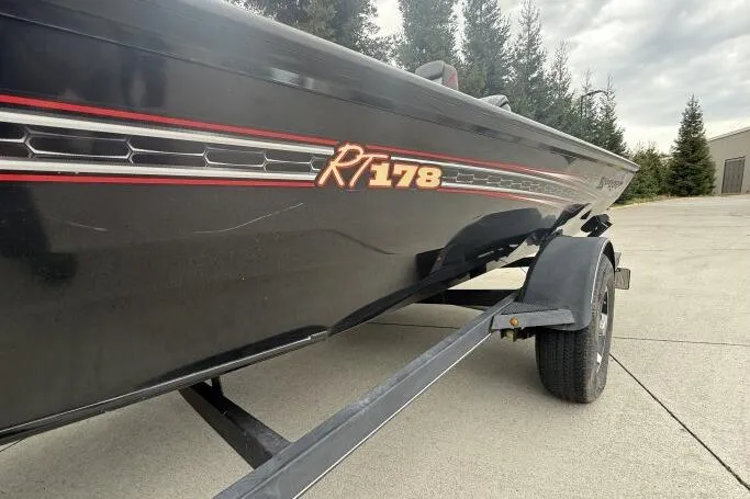 Slide: The Image of 2021 Ranger RT178 boat on trailer, black with red accents, parked outdoors. - 9