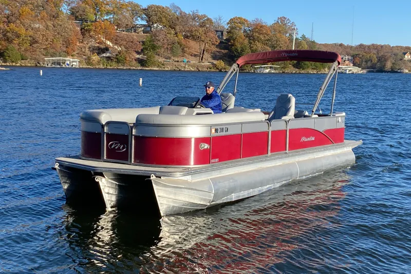 The Image of 2020 Manitou 25 Oasis SR SHP pontoon boat on a scenic lake. - 0
