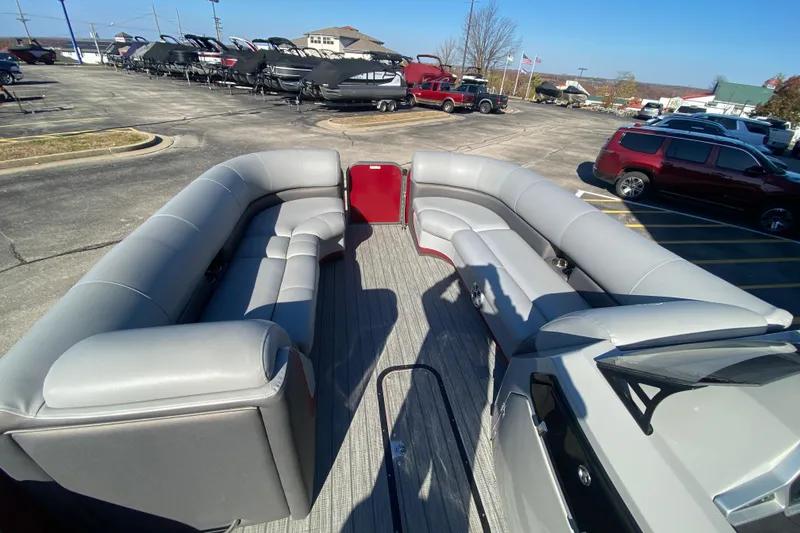 Slide: The Image of 2020 Manitou 25 Oasis SR SHP pontoon boat with spacious seating in a parking lot. - 15