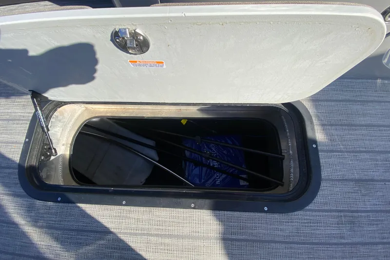 Slide: The Image of Open storage compartment on 2020 Manitou 25 Oasis SR SHP boat deck. - 18