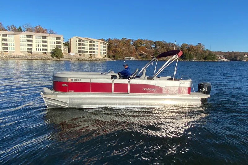 Slide: The Image of 2020 Manitou 25 Oasis SR SHP pontoon boat on a lake with scenic background. - 2