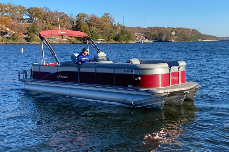 Slide: The Image of 2020 Manitou 25 Oasis SR SHP pontoon boat on a scenic lake. - 5