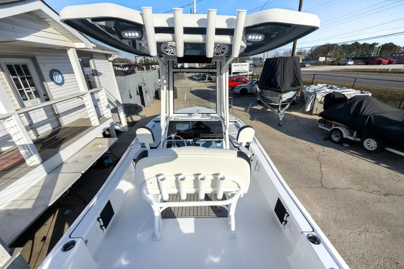 Slide: The Image of 2026 Tidewater 2210 Carolina Bay boat with T-top and rod holders, parked at a marina. - 10
