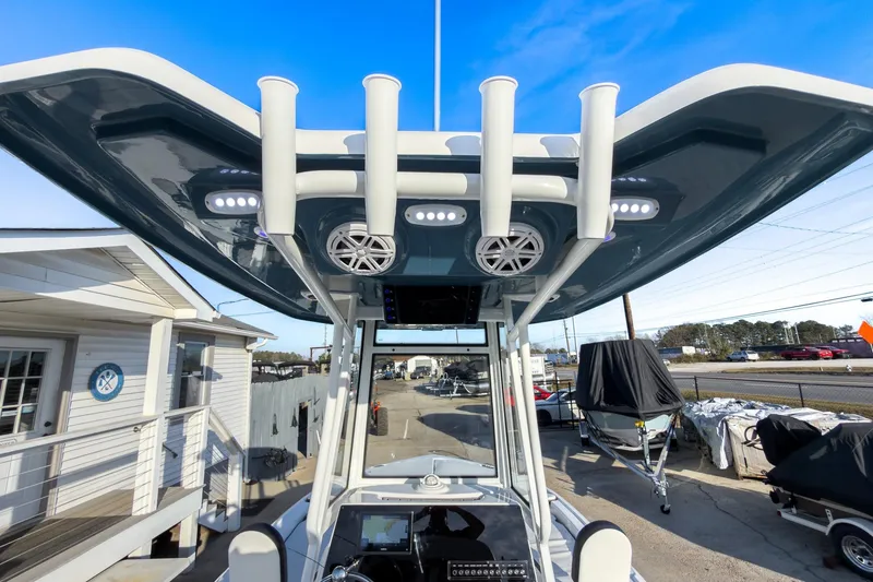Slide: The Image of 2026 Tidewater 2210 Carolina Bay boat with T-top and rod holders, docked at marina. - 13