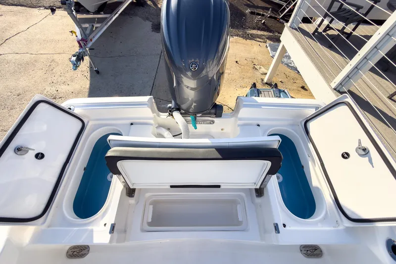 Slide: The Image of 2026 Tidewater 2210 Carolina Bay boat with open storage compartments and outboard motor. - 24