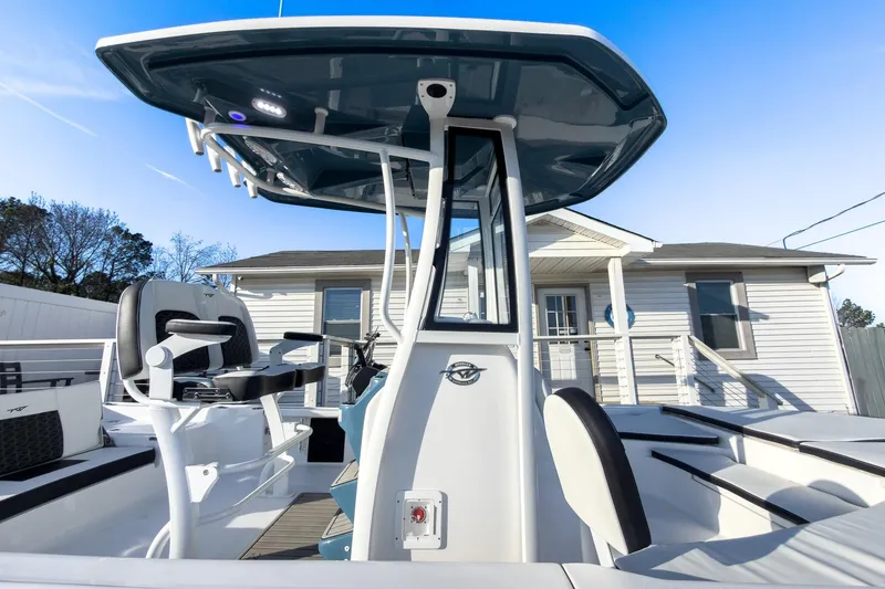 Slide: The Image of 2026 Tidewater 2210 Carolina Bay boat with modern console and seating, docked near a house. - 29