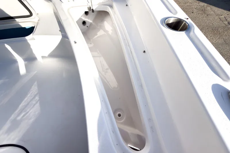 Slide: The Image of 2026 Tidewater 2210 Carolina Bay boat interior with storage compartment and cup holder. - 35