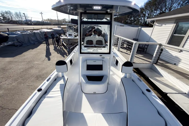 Slide: The Image of 2026 Tidewater 2210 Carolina Bay boat, sleek design, docked outdoors, with people nearby. - 41