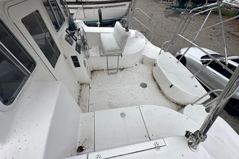 Slide: The Image of 2014 Gemini Legacy 35 sailboat on land, covered with a blue tarp, near a stone wall. - 18